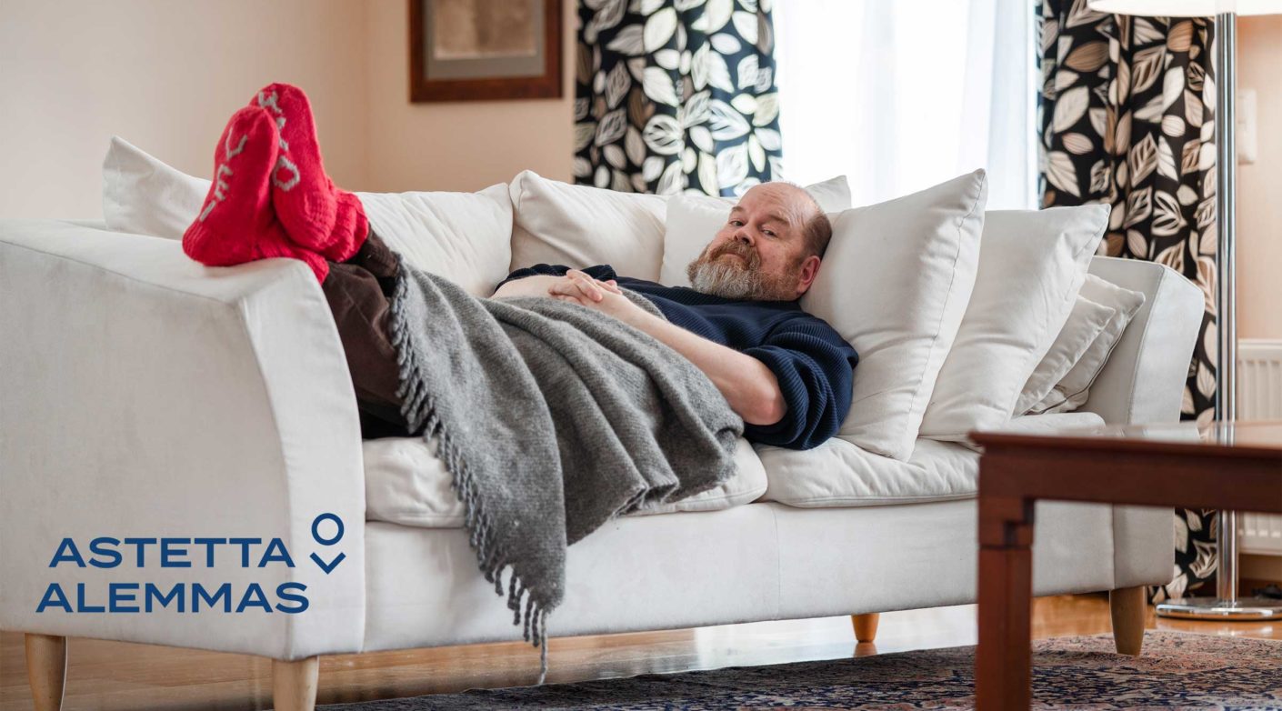 Mies makaa sohvalla villasukat jalassa