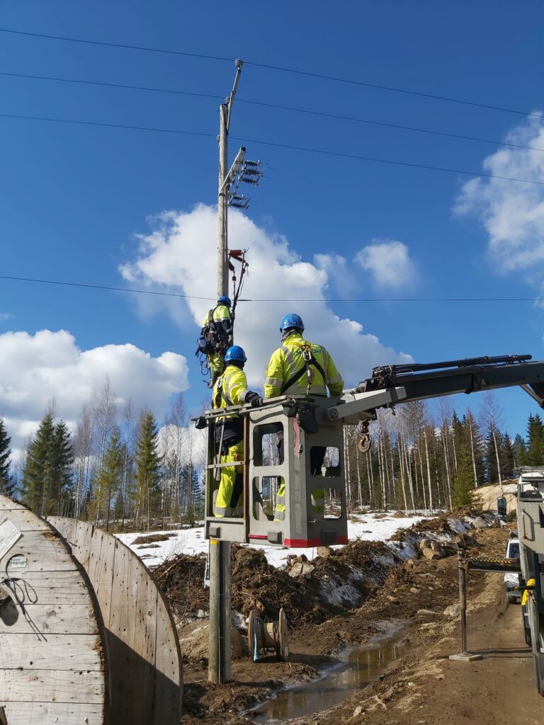 Miehet työmaalla, päällä työvaatteet, joissa lukee Omexom