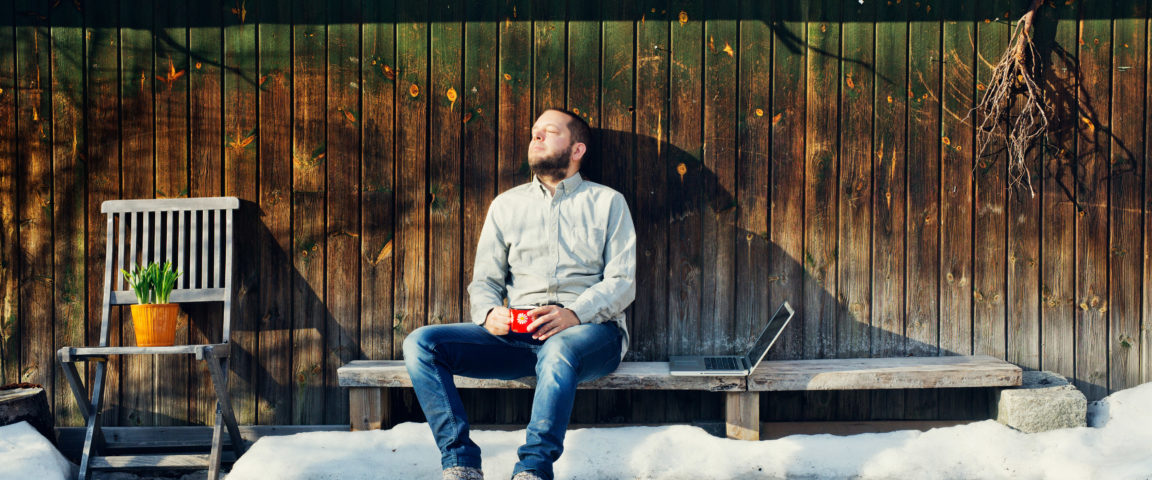 A man sitting outdoors and having coffee