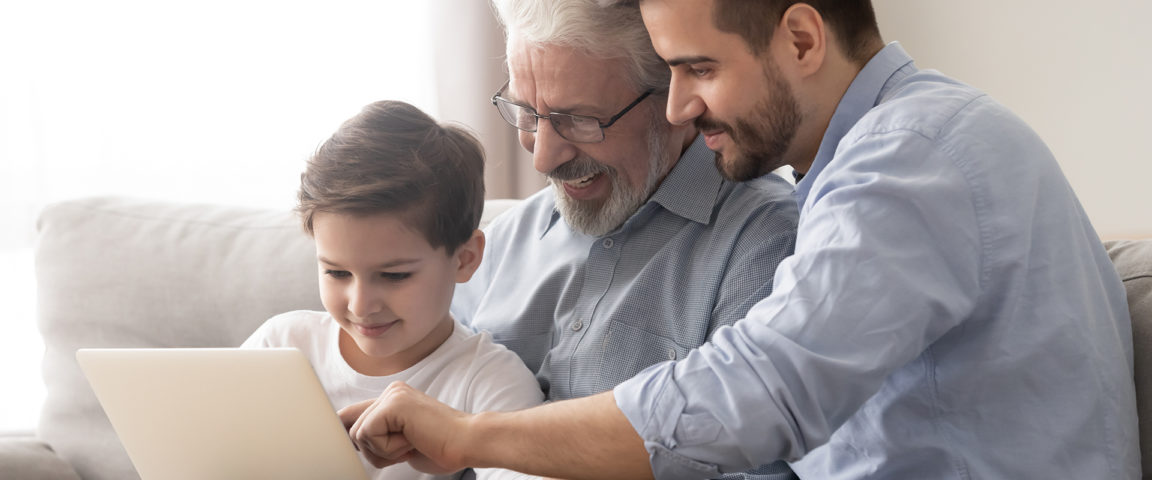 Poika, isoisä ja isä kannettavalla tietokoneella