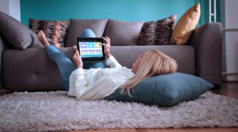 Woman lying on the floor with a tablet